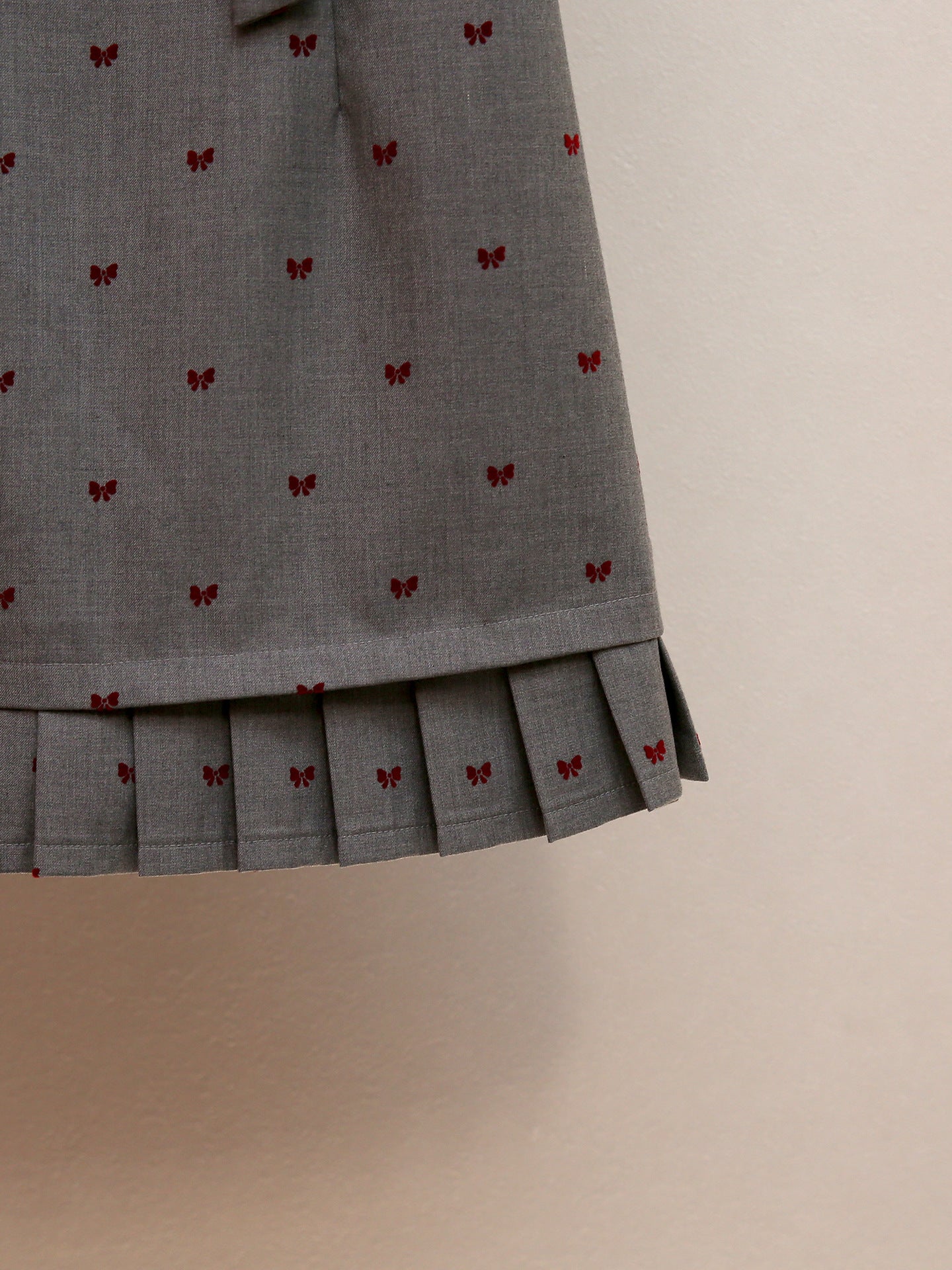 Haruye Playful Bow Print Sleeveless Mini Dress | Scalloped V-Neck & Pleated Hem